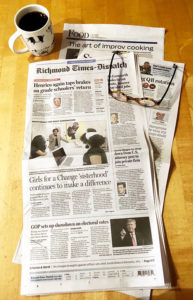 Newspaper cover page, cup of coffee and glasses lying on top of it