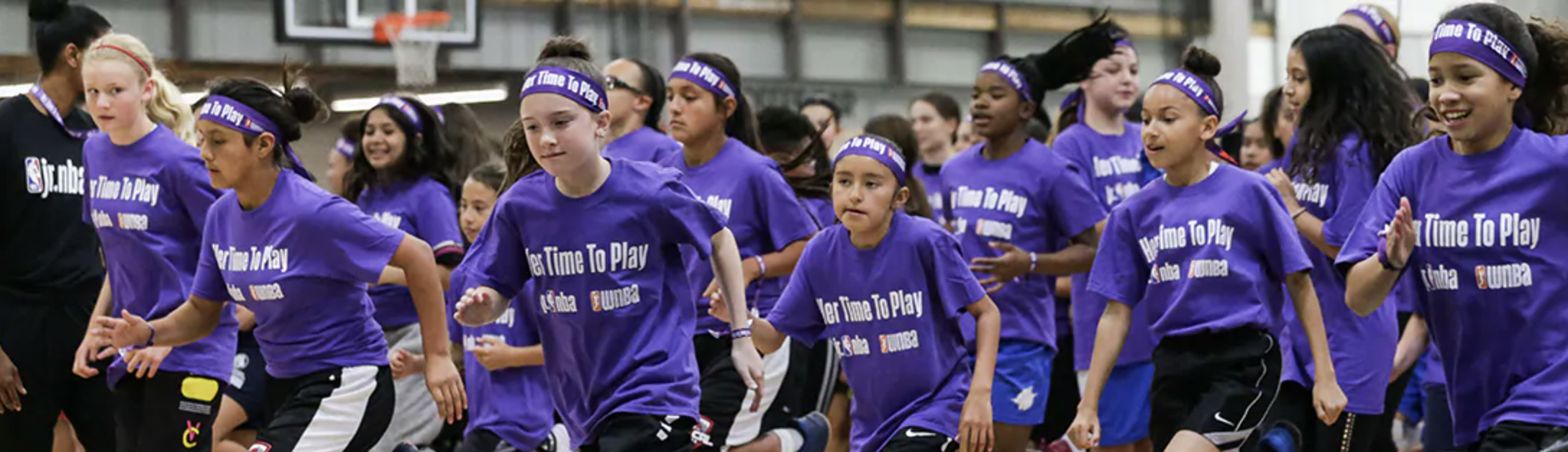 group of girls running in purple t-shirrts